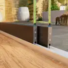 Steellook glazen schuifwand met 2 rails closeup van de rails met 2 verschillende vloeren aan beide kanten