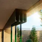 Steellook glazen schuifwand met 3 rails, bovenrails goed zichtbaar met een tuin en leuke schutting zichtbaar