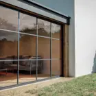 Steellook glazen schuifwand met 4 rails, door specialisten gelegd met mooie bank binnen ingericht