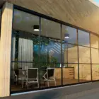 Steellook glazen schuifwand met 5 rails, midshot en ingericht met stoelen en een tafel en planten