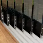 Steellook glazen schuifwand met 6 rails, wanden verspreid over de rails met 2 verschillende vloeren aan de kanten