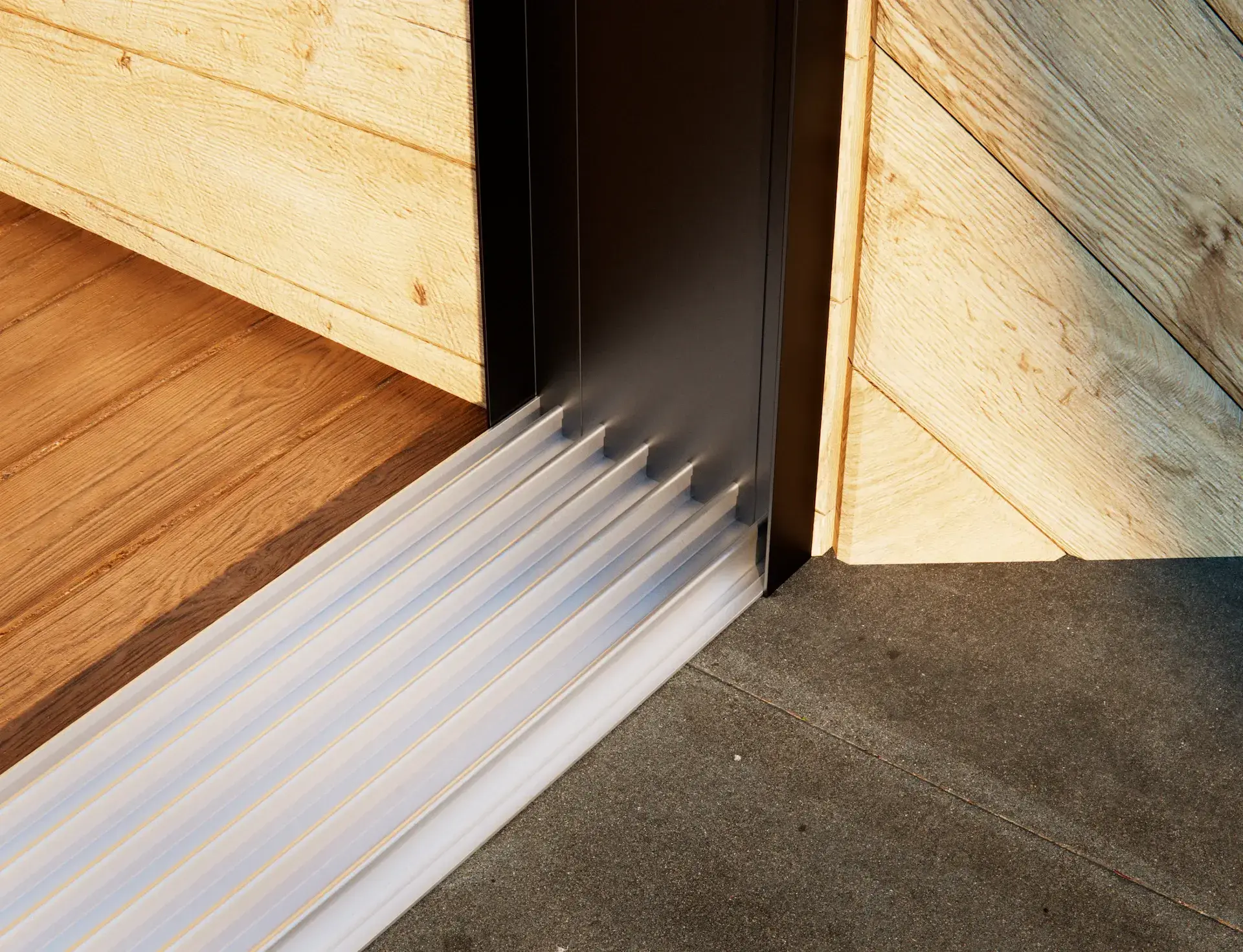 Steellook glazen schuifwand met 6 rails, alleen rails zichtbaar en houten muur ernaast zichtbaar