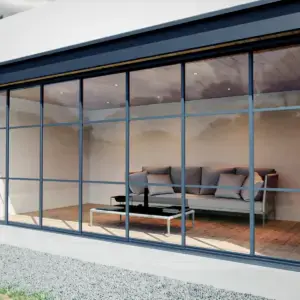 Steellook glazen schuifwand met 7 rails, vanaf buiten naar binnen kijkend, houten vloer binnen en grijze bank met gras en een paadje in de tuin