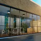Steellook glazen schuifwand met 7 rails met lichten aan de binnenkant, gordijnen en leuke stoelen