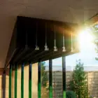 Steellook glazen schuifwand met 7 rails, bovenrails met zon in zicht en veel planten en bomen